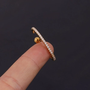 Macro shot of gold stainless steel cartilage stud with cubic zirconia inlays