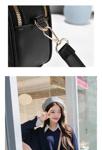 Close-up of black litchi grain leather texture and premium gold metal zippers on handbag