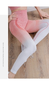 Detail of high-waisted seamless yoga leggings with coral-to-white gradient and ribbed texture