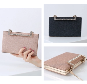 Detail of glitter evening clutch with rhinestone handle and detachable gold chain strap
