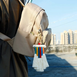 Porte-clés macramé arc-en-ciel bohème avec fermoir doré sur un sac à dos