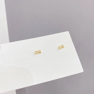 Elegant gold bow earrings with micro-set zircon stones on white display card
