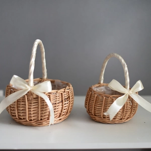 Detail of two woven flower baskets with beige silk bows and natural wicker texture