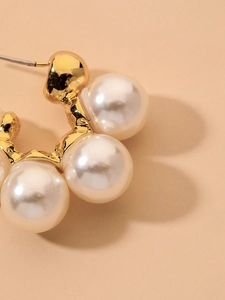 Detailed view of C-shaped gold earring with four elegant pearls and textured finish