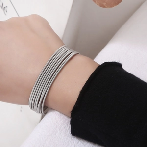 Close-up of multilayer stainless steel wire spring bracelet on wrist with silver finish