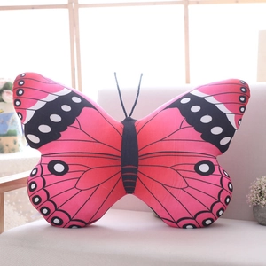 Detailed pink butterfly plush pillow on a beige sofa with realistic wing patterns