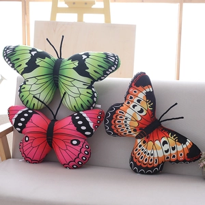 Lifelike butterfly plush pillows in green, red and orange on a modern sofa for room decor