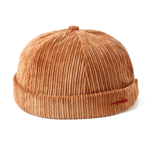 Vintage caramel brown corduroy docker hat with red embroidery and warm autumn texture