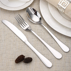 Three-piece stainless steel cutlery set with knife, fork and spoon on a beige placemat