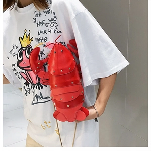 Detail of red lobster-shaped bag with shiny PU leather texture and gold metal rivets