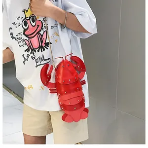 Close-up of red lobster shaped crossbody bag with gold chain strap on a model