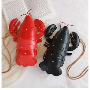Detailed view of red and black lobster shaped PU leather bags with gold chain straps