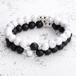 Close-up of matte black agate and white marble stone distance bracelets with magnetic charms