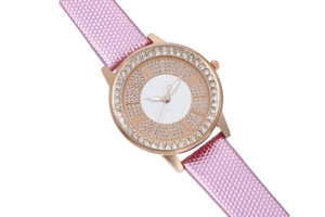 Macro shot of rose gold watch bezel with pink leather strap and white crystals