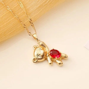 Golden necklace with a cute bear pendant featuring a vibrant red gemstone inlay