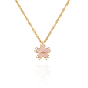 Macro detail of a cherry blossom pendant with pink petals and a crystal core on a gold chain