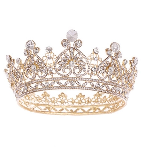 Close-up of golden crown featuring intricate filigree and sparkling clear crystals