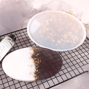 DIY epoxy resin craft kit with oval silicone mold, gold foil coaster, and resin glue