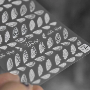 Macro detail of Tomoni 5D nail stickers featuring delicate white insect wing textures