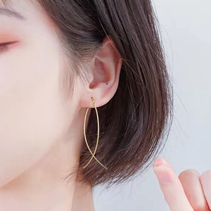 Close-up of golden tassel drop earrings featuring elegant long flowing curved lines on model