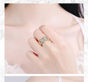 Close-up of a gold chain ring with pavé diamonds on a hand over marble background