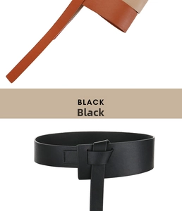 Detail of wide leather belts in black and tan with a unique knot buckle design