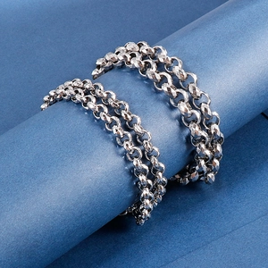Detail of silver stainless steel multi-faceted chains on blue cylindrical stand