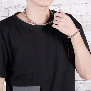 Silver stainless steel chain necklace and bracelet set displayed on a male model