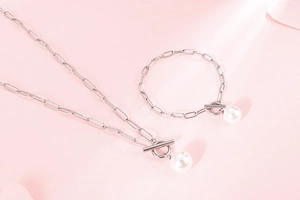 Detail of silver paperclip chain necklace and bracelet set with elegant pearl pendants