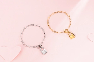 Detailed view of gold and silver paperclip bracelets with padlock charms and OT toggles