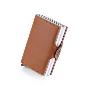 Macro detail of brown leather texture and aluminum pop-up card holder mechanism