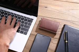 Top view of a brown leather RFID blocking metal card holder on a professional wooden desk