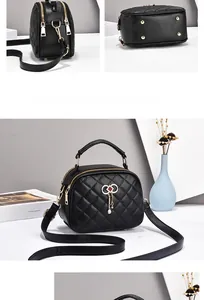 Detail of black quilted leather handbag with gold bow tassel and dual zipper closure