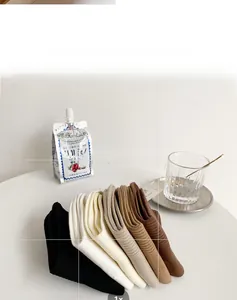 Gros plan de chaussettes en maille côtelée pour femmes en noir, blanc et café