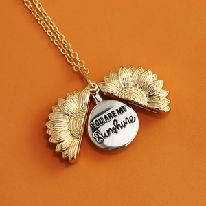 Detail view of sunflower locket necklace engraved with You Are My Sunshine text