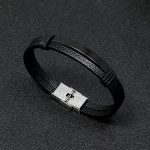 Detail of double-layer black leather men's bracelet with stainless steel clasp and plaque