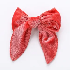 Barrette à cheveux nœud en velours rouge fait main avec texture rayée sur fond blanc