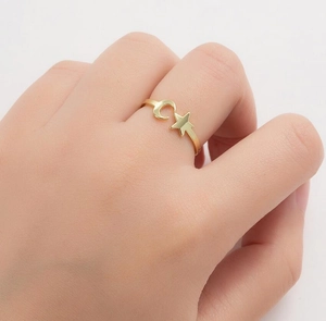 Detailed view of an adjustable gold star and crescent moon open ring on a woman hand