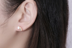 Close-up of a model wearing cute rainbow cloud earrings with macaron enamel colors
