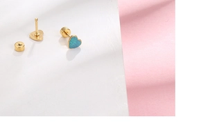 Macro shot of gold heart studs with blue glitter inlay and secure screw backings