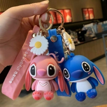 Dettaglio di ciondoli Stitch in silicone rosa e blu con charms a margherita