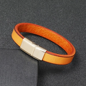 Macro shot of orange leather bracelet with polished gold magnetic clasp detail