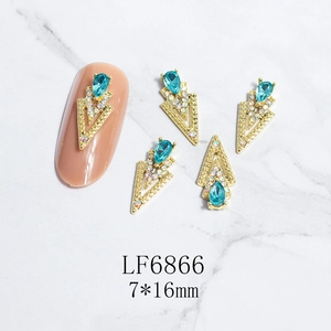 Detail of 3D nail art charms with golden alloy triangle frame and blue teardrop rhinestone
