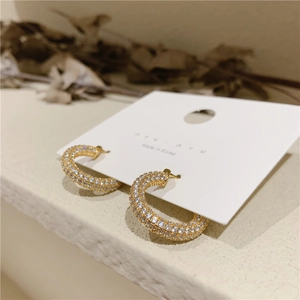 Macro shot of gold-plated C-shaped earrings with micro-pave white cubic zirconia