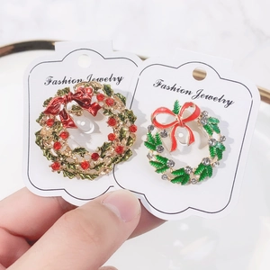 Festive Christmas wreath brooches set with red bows and sparkling rhinestones