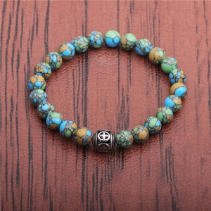 Detail of agate stone bead bracelet featuring a vintage metal cross charm on leather
