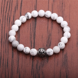 Detail of white howlite beads bracelet with vintage silver hollow cross charm on leather