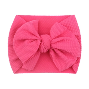 Pink newborn baby headband featuring a large bow in soft ribbed elastic fabric