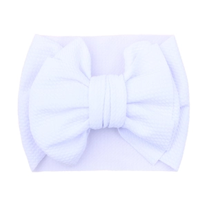 Soft white baby headband with large waffle texture bow for infants and toddlers
