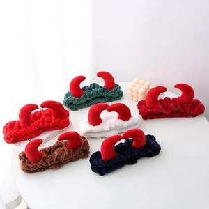 Détail de bandeaux en peluche avec cornes de diable en plusieurs couleurs sur présentoir